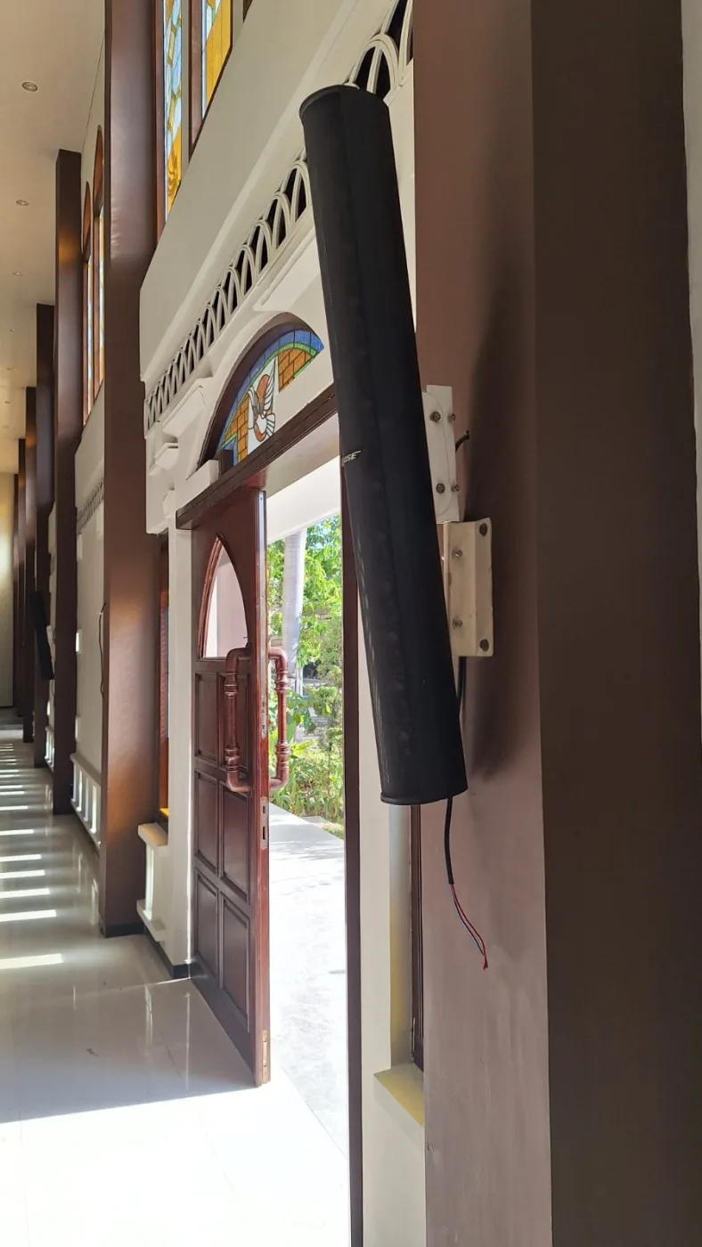 A column speaker mounted on a pillar, following the lines of the building.